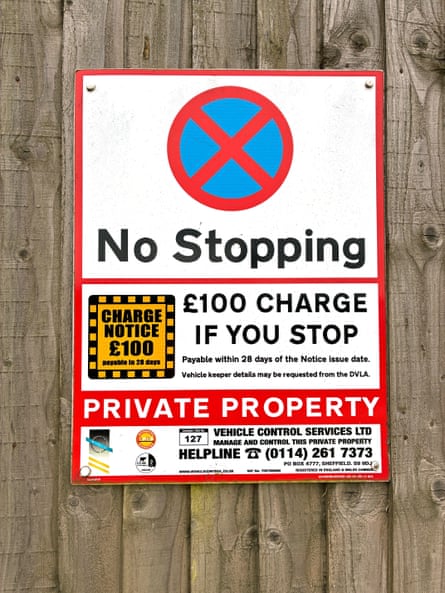 A "No Stopping" sign warning of a £100 charge is fixed to a wooden fence at Bristol Airport