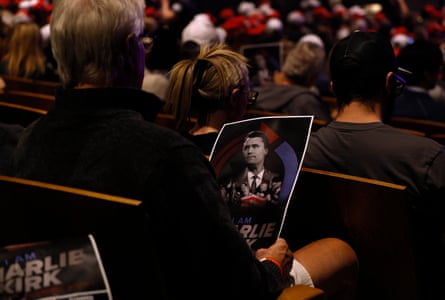 Person holds Charlie Kirk poster