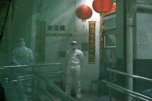 Personnel wearing protective suits supervise the evacuation of residents from a housing estate in Hong Kong after two cases of coronavirus were confirmed.