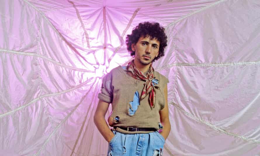 Kevin Rowland of Dexys Midnight Runners wearing a torn jumper and a bandana over dungarees