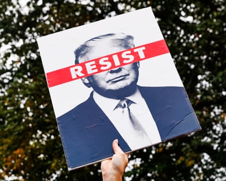 A protester holds up a ‘resist Trump’ placard