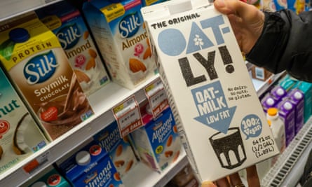 person holds carton of oatly oat milk