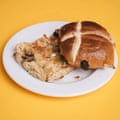 A Waitrose St Clements hot cross bun, sliced, toasted and buttered, on a white plate