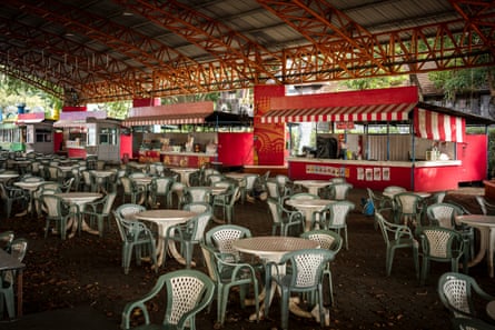 Food stalls stand in a row alongside empty chairs