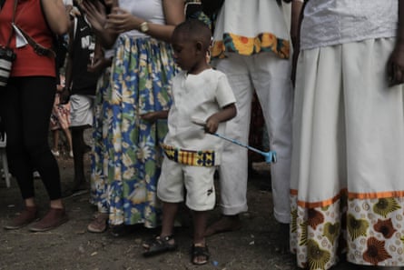 A young Black boy in white T-shirt and white shorts.