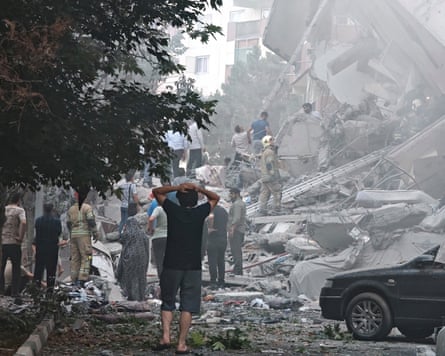 People look over at damage to buildings in Nobonyad Square following Israeli airstrikes in Tehran