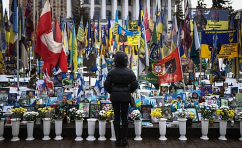 a person stands in front of a makeshift memorial for Ukrainian and foreign soldiers in Independence Square.