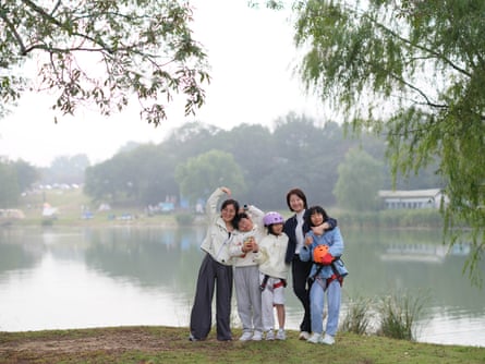Fei and Zhu with their children beside a lake