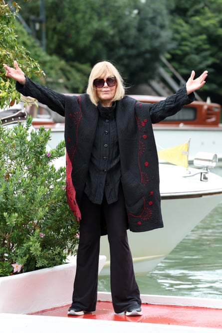 Kim Novak gives a welcoming gesture to photographers at a Venice dock.