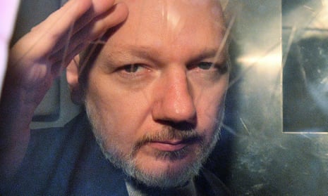 Julian Assange gestures from the window of a prison van