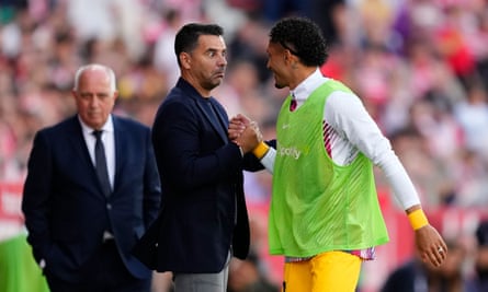 The Girona head coach, Michel, gets a handshake from Barcelona substitute Raphinha.