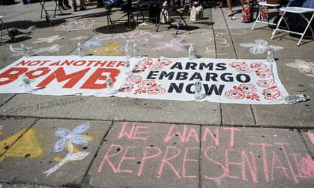 Sidewalk with red, white and black sign that says Not Another Bomb and Arms Embargo Now, and chalk drawings.