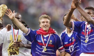Didier Deschamps waves and defender Lilian Thuram holds the trophy at the Stade de France.