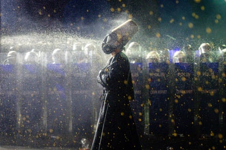 A protestor wearing a gas mask and dressed as a whirling dervish is pepper sprayed by police during clashes with police in Istanbul, prompted by the arrests of politicians, business leaders and journalists that their supporters claim were politically motivated