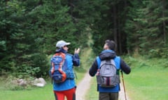 Two walkers head into woods on the Juliana walking trail in Slovenia.