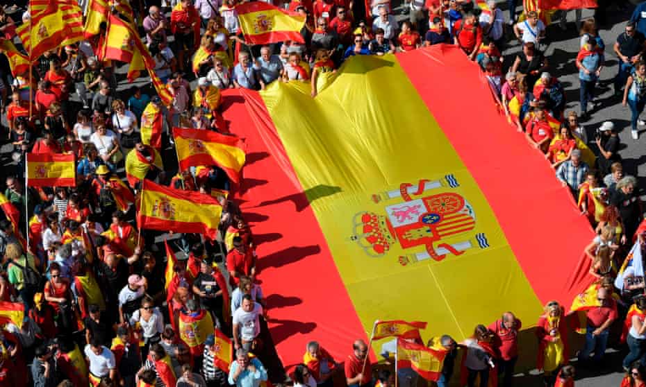 Protesters hold a giant Spanish flag during a demonstration to support the unity of Spain on 8 October in Barcelona.