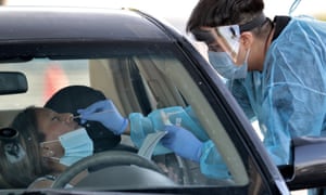 People are tested for coronavirus in their in vehicles in Phoenix’s western neighborhood of Maryvale.