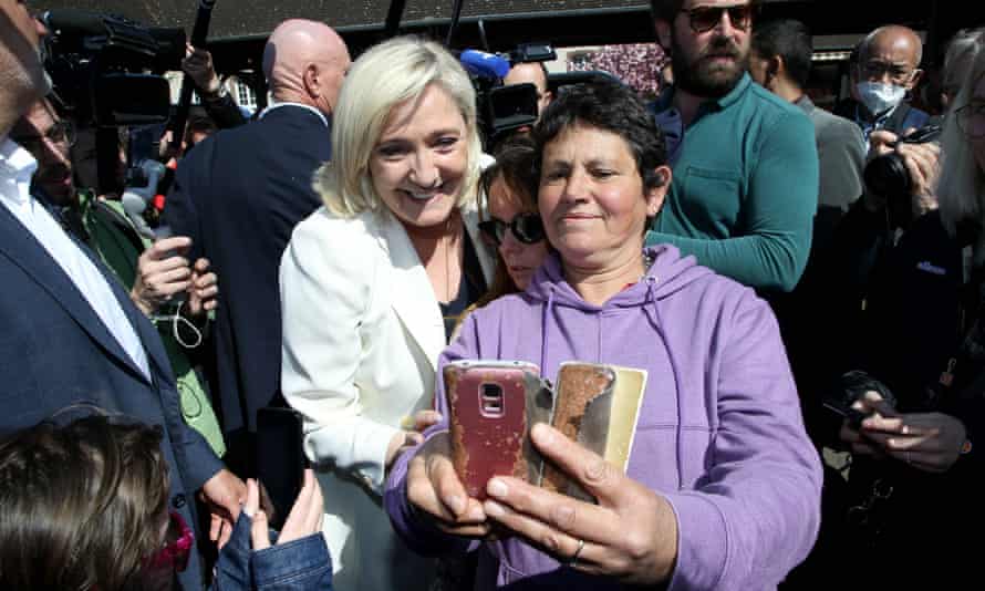 Marine Le Pen poses for a photo with a member of the public during a campaign visit to Saint-Remy-sur-Avre, north-west France, on Saturday