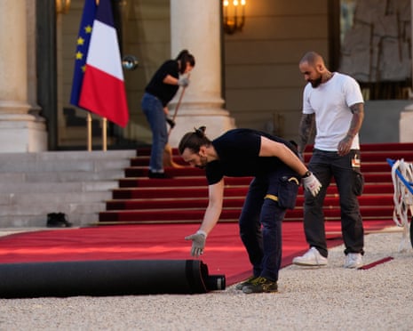 Workers set up a red carpet at the Élysée Palace to welcome Pope Leo XIV.