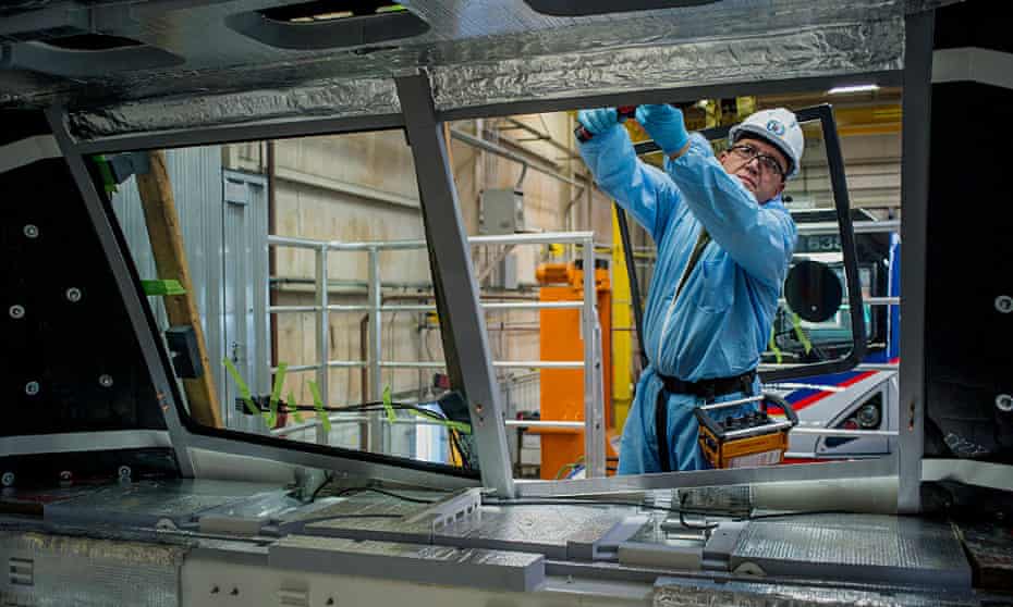 An employee installs the windshield of an Amtrak locomotive at the Siemens manufacturing facility in Sacramento, California.