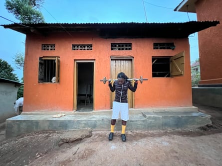 a girl in shorts lifting weights outside a small house