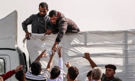 Palestians pass water bottles that have just arrived in Gaza City.