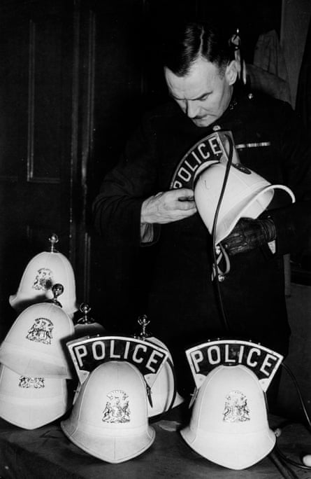 A Salford policeman prepares illuminated helmets for wear when assisting pedestrians and traffic during the blackout hours of winter, October 1940.