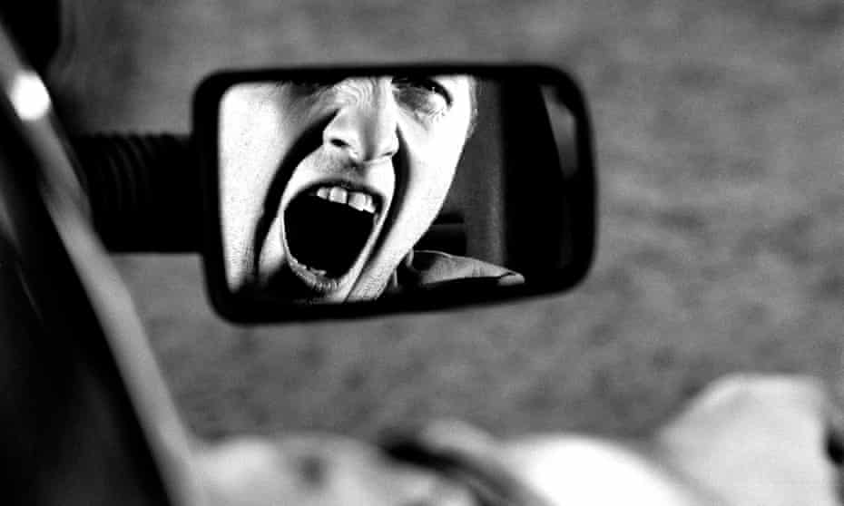 A man in a car yelling in rage