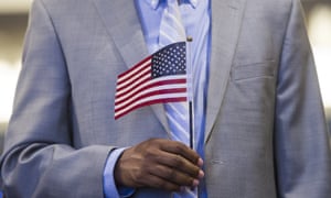 A man holds an US flag prior to taking the citizenship oath.