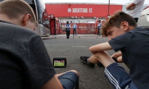 Fans who aren’t allowed into Griffin Park because of Coronavirus restrictions, have to make do watching the action on a tablet outside the stadium.