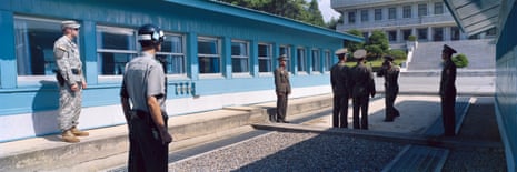Panmunjom, Demilitarized Zone, Korea, September 2009South and North Korean military police officers standing next to the barrack where the armistice was signed in 1953. The curb marks the demarcation line between the two countries. To the left is an American soldier.