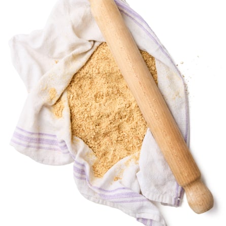 A tea towel with biscuit crumbs and a rolling pin