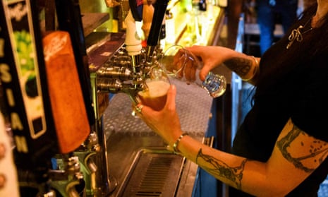 A bartender pours beers
