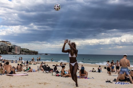 A woman plays with friends at Bondi beach on Saturday as temperatures soared to 33C