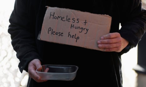 A beggar holds a notice saying: 'Homeless + Hungry. Please help.'