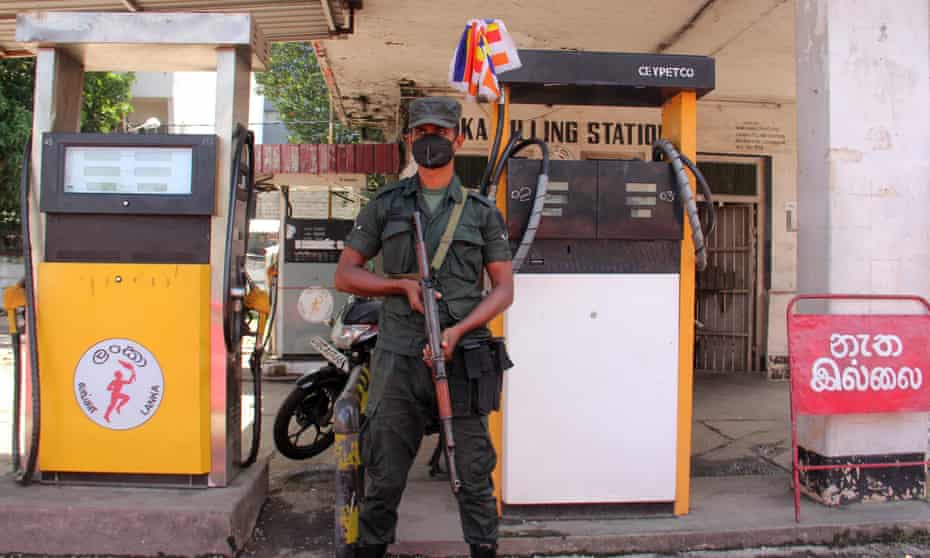 A member of Sri Lanka’s security personnel stands guard as a fuel station in Colombo