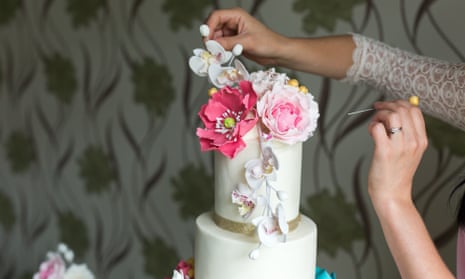 A pâtissier puts the final touches to a wedding cake.