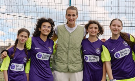 Jill Scott poses with girls from a grassroots football team.