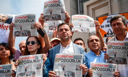 Protesters hold copies of the Cumhuriyet newspaper