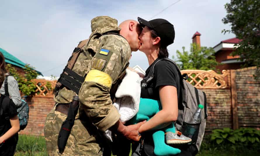 A family reunification takes place when a woman carrying a baby reacts after evacuating from Russian troop-occupied Kupiansk town in a bus convoy