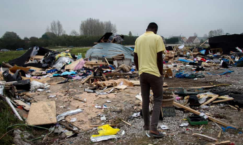 A man walks past debris in the Calais camp as the clearance enters its final stage.