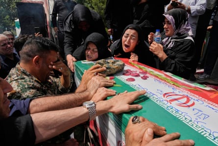 People mourn over the flag-draped coffin of a member of the paramilitary who was killed in Israeli attacks in Tehran, Iran