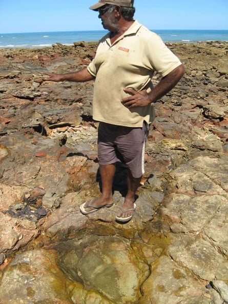 Goolarabooloo elder Phillip Roe stands in front of a dinosaur footprint near James Price Point, north of Broome, Western Australia.