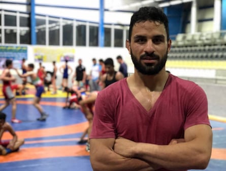 Navid Afkari Sangari, a wrestler who was executed in 2020, stands with arms crossed in a wrestling gym