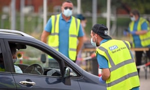 Workers in NHS test and trace jackets at a Covid-19 testing centre in Bolton, north-west England