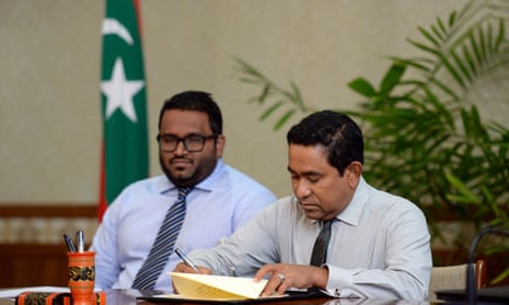The Maldivian president, Abdulla Yameen, ratifies the law allowing foreign ownership of land for the first time, watched by the vice-president, Ahmed Adeeb. India is concerned at Beijing’s growing influence in an area it regards as its backyard. 