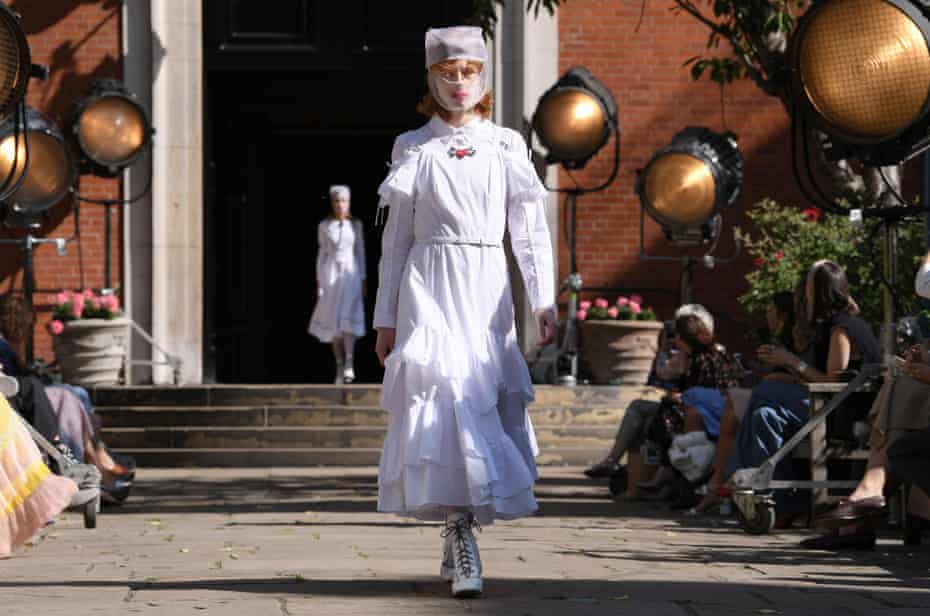 A model in head-to-toe white dress, with gauze mask, at Bora Aksu's fashion show