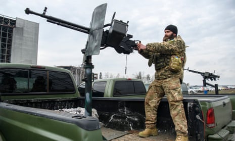 Un membre du groupe mobile de défense aérienne, également appelé chasseurs de drones, vérifie une mitrailleuse au sommet d'une camionnette, à l'aérodrome de Hostomel près de Kiev, en Ukraine.