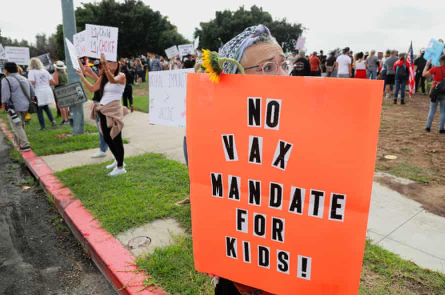 A woman holds an anti-vaccine sign reading "No vax mandate for kids!" during a protest outside a San Diego Unified school district hearing on 28 September.
