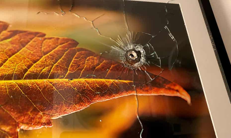 A bullet hole is seen in a framed photograph hanging on a wall following a shooting that happened at a neighbouring unit, in Toronto, Canada, on Tuesday.